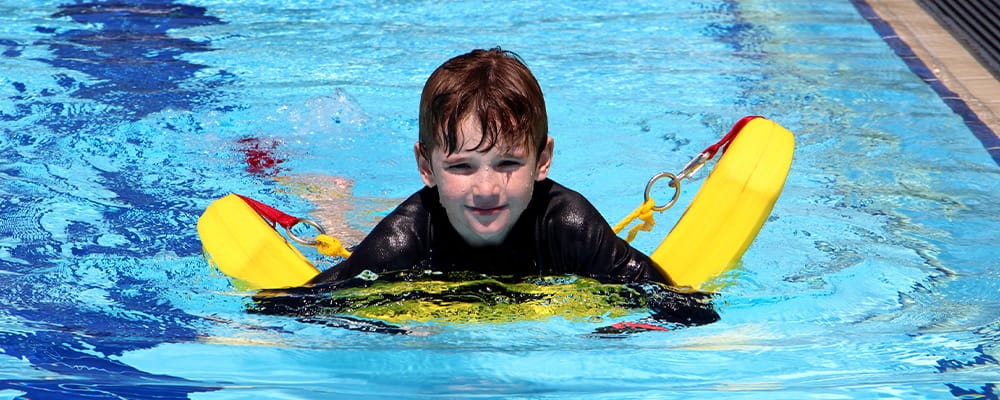 Child floating on rescue tube in pool