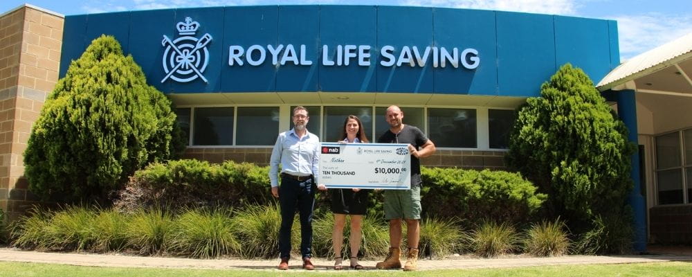 Royal Life Saving WA's Allan Godfrey and Laura Kazmirowicz with raffle winner Nathan