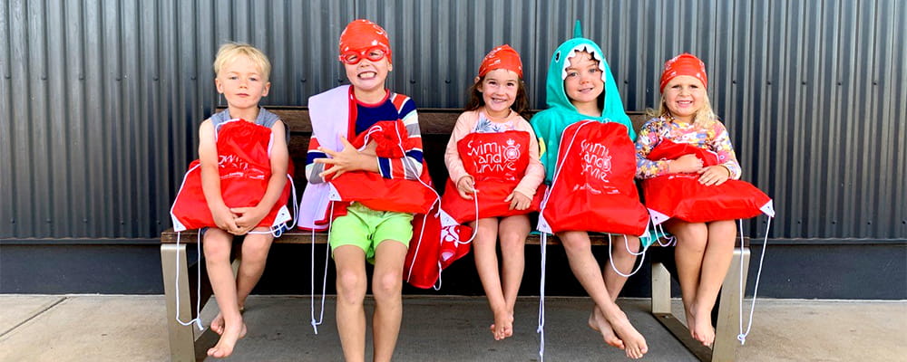 Onslow children sitting on a bench after a swimming lesson