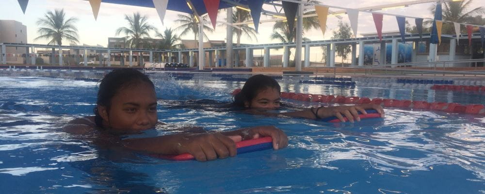 Pida Bule-Turner and her sister, Maliriko, paddle in the Port Hedland Pool with kickboards.