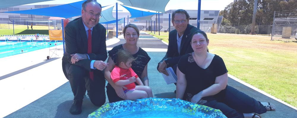 Commerce Minister Bill Johnston, Maree and daughter Zara, Royal Life Saving CEO Peter Leaversuch and Drowning Prevention Ambassador Melanie Mitchell by a blow-up paddling pool
