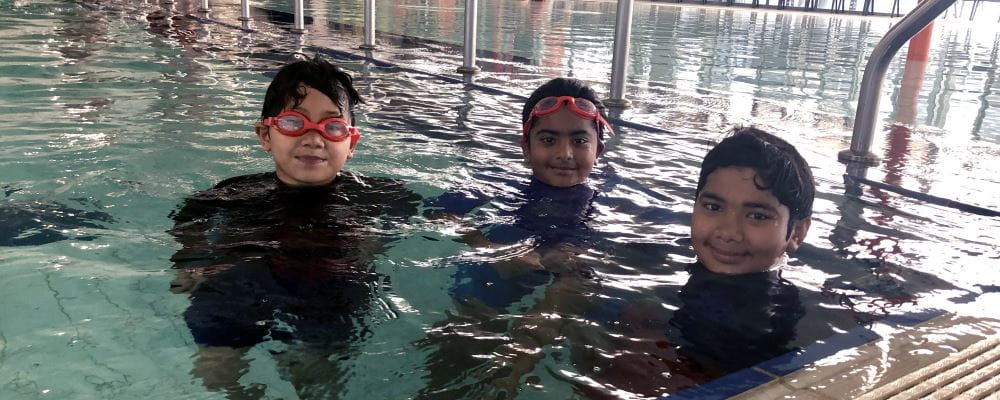 Three multicultural boys in the pool at Cannington