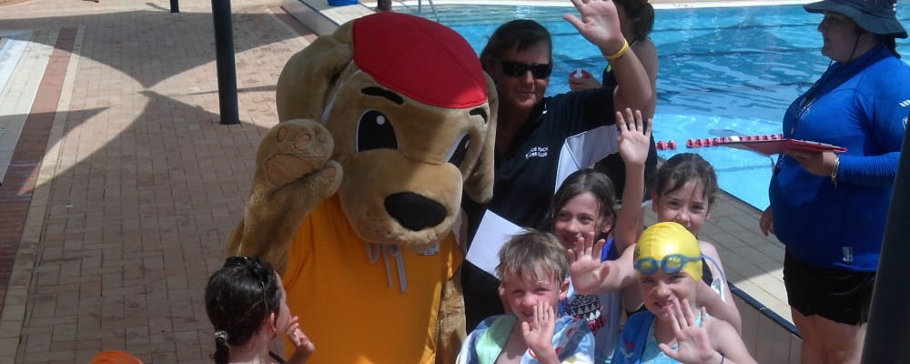 Rodena Lightbody with Walter the Watchdog and a group of children at Bruce Rock pool