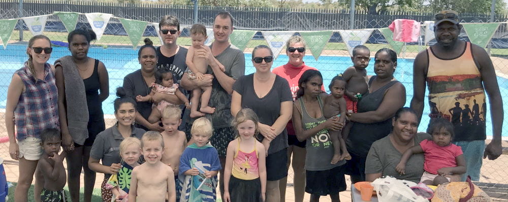 Parents with their children and instructor Adele Caporn by the pool at Fitzroy Crossing
