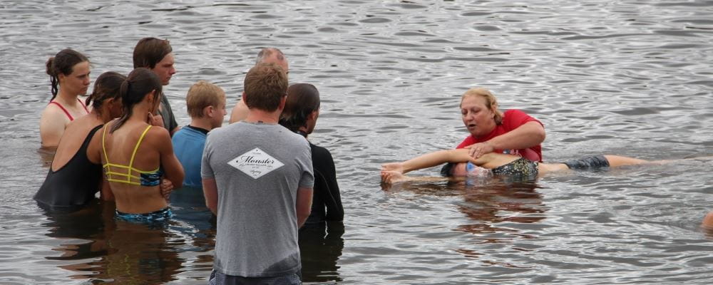 Imge of kids in the Swan River with instructor demonstrating