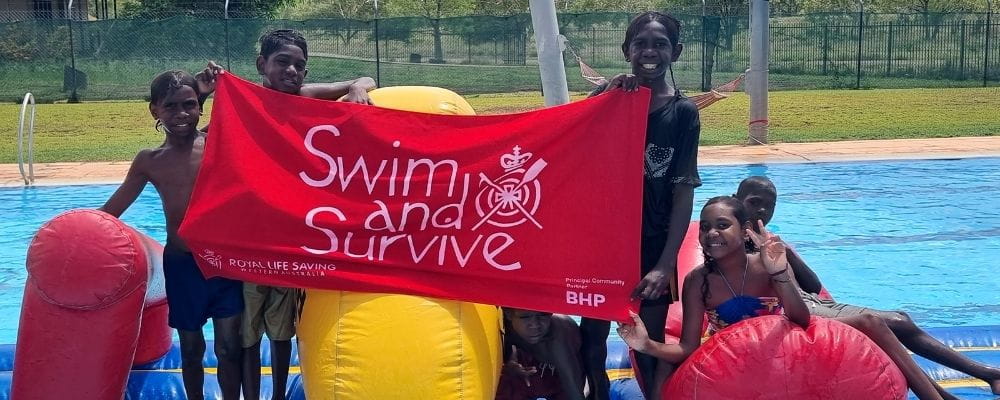 Warmun children holding Swim and Survive banner at Warmun Pool