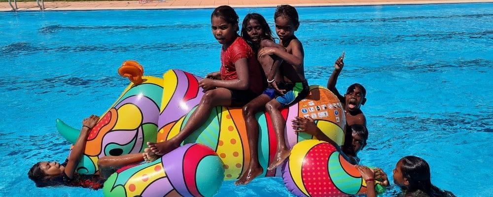 Warmun children on giant inflatable rhino at the Warmun pool