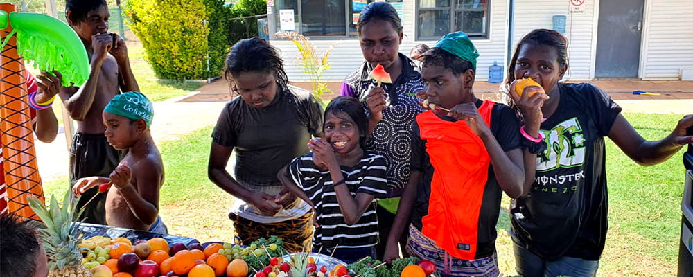Warmun Aboriginal children tucking into a table laden with fruit