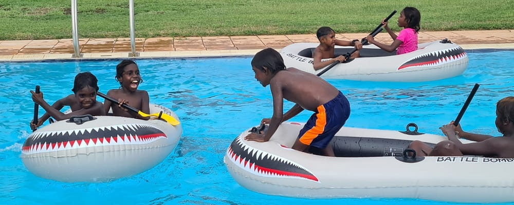 Warmun children having an inflatable boat battle at the pool