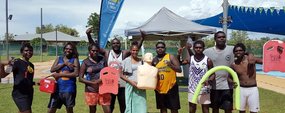A group of Warmun youth with rescue gear and a CPR manikin at the Warmun pool