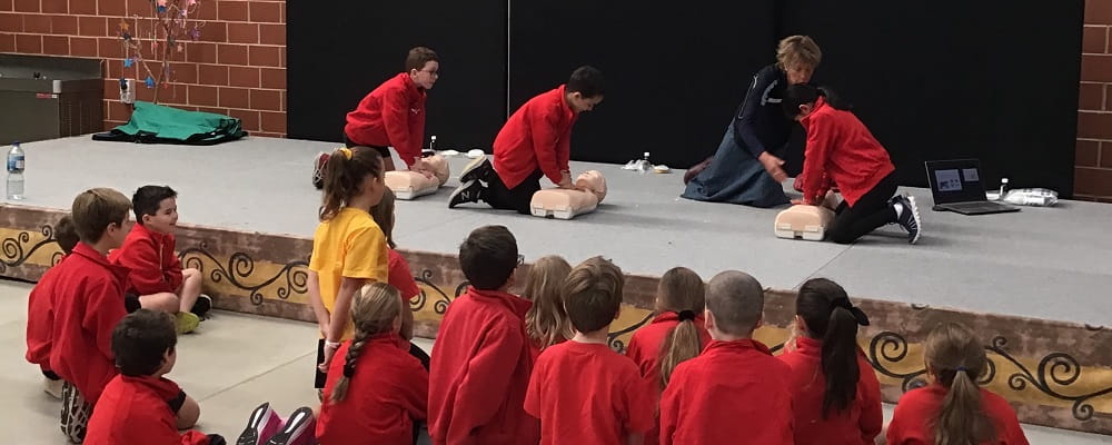 primary school students learning CPR