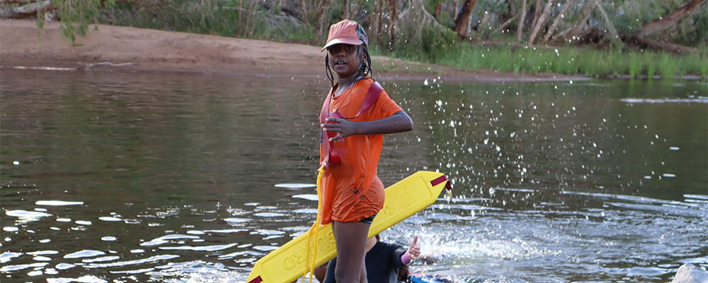 An Aboriginal child with a rescue tube by the river