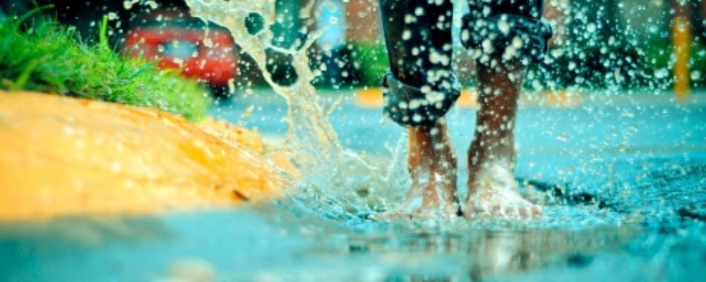 image of a person's feet splashing in a puddle