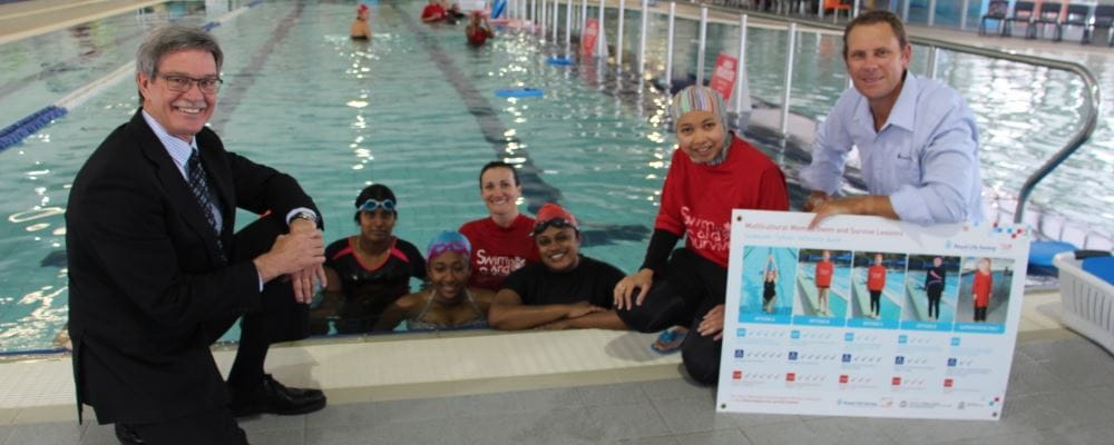 Minister for Multicultural interests Mike Nahan, with Swim Instructor Titisari Titisari and Royal Life Saving Society CEO Peter Leaversuch beside the pool with women taking part in a women's only lesson