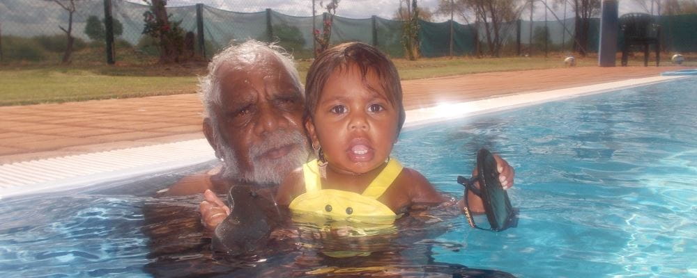 Toddler in the pool with grandfather at Yandeyarra