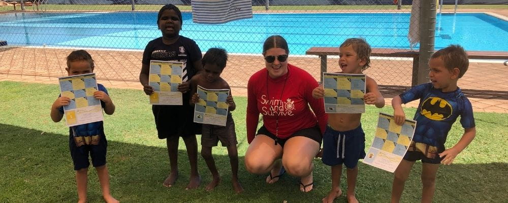 Zoe Ross with a group of Aboriginal children by the pool