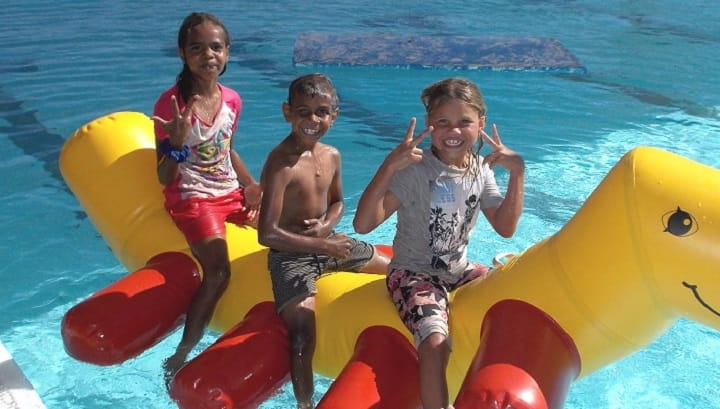 three Burringurrah Aboriginal children on a pool inflatable