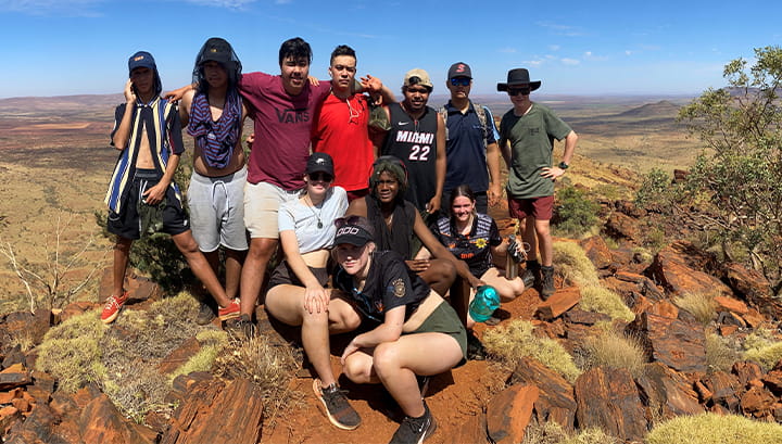Pilbara youth sitting as a group on Mount Bruce