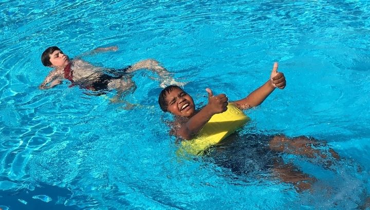 Two children in the pool practising rescue skills