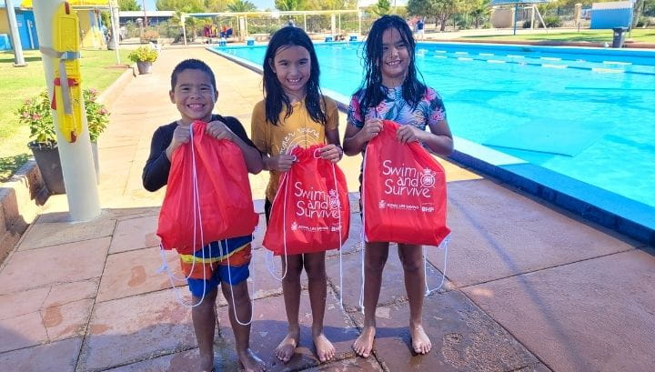 Three girls holding Swim and Survive bags at Exmouth Pool