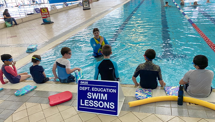 six students in the middle of a swimming lesson