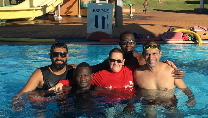 multicultural men in a pool after a swimming lesson