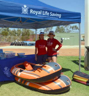 Two swim instructors in a Royal Life Saving tent with two inflatable boats