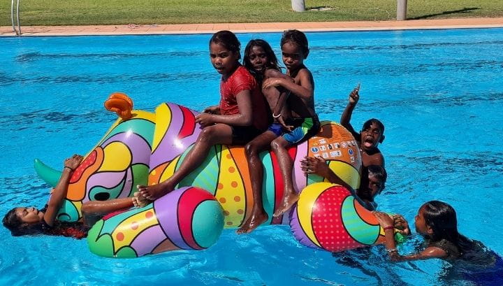 Warmun children enjoying a giant pool inflatable