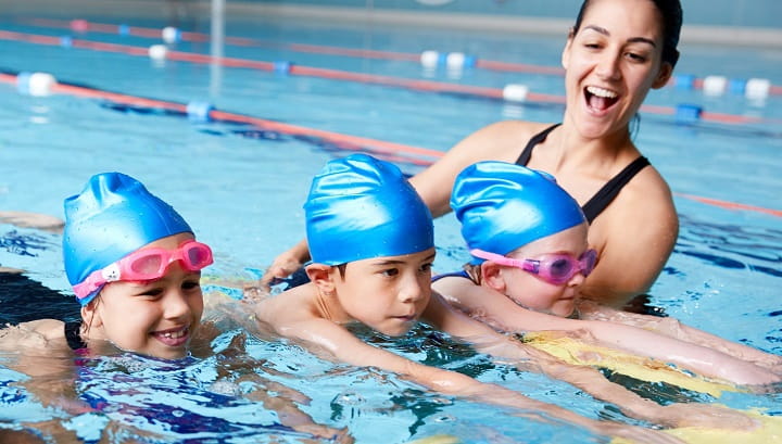 swimming instructor with students in pool