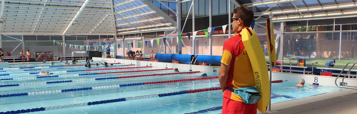 A lifeguard standing by a pool
