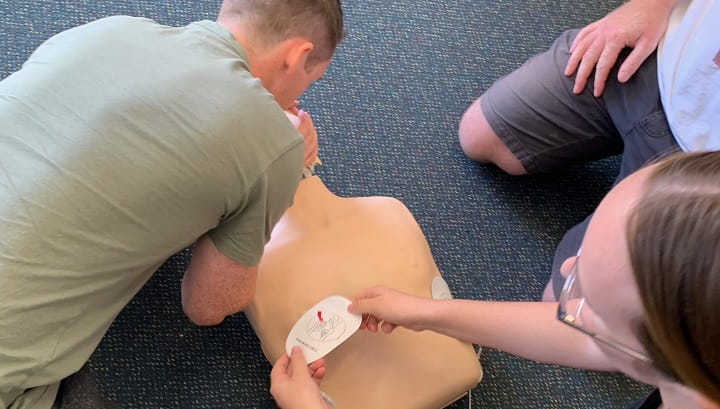 close up of people practising CPR on a manikin