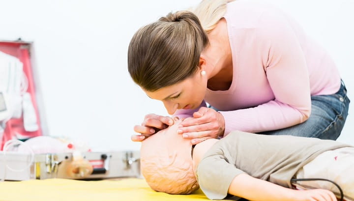 woman practising resuscitation on a manikin