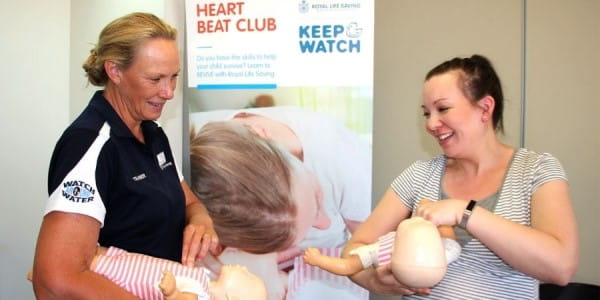 A trainer demonstrates infant CPR on a manikin