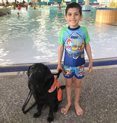 Comet the autism assistance dog with Adam by the pool at Swan Active Beechboro