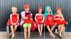 5 children post swim lessons sitting on bench