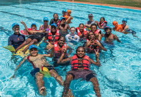 A group of aboriginal youth in the pool with their trainer at Jigalong