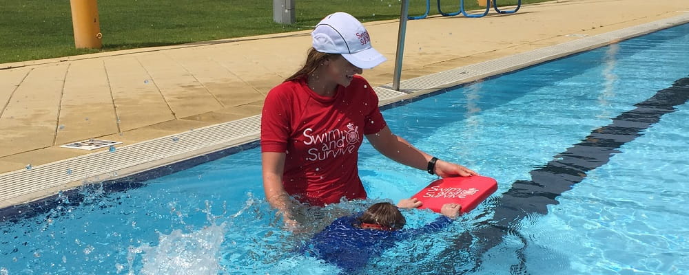swimming instructor with student in pool