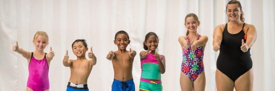 children standing in a row giving to thumbs up