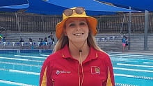 female lifeguard standing in front of pool