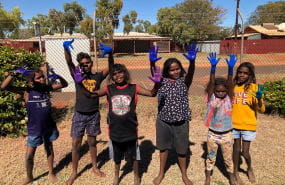 A group of Aboriginal children holding up their painted hands