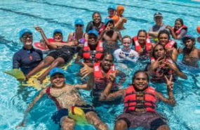 A group of young people in the Jigalong remote pool wearing lifejackets 