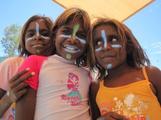 image of 3 aboriginal girls with faces painted smiling at the camera
