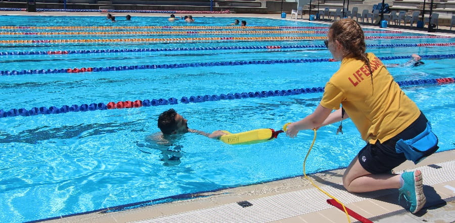 A lifeguard rescuing a person from a pool