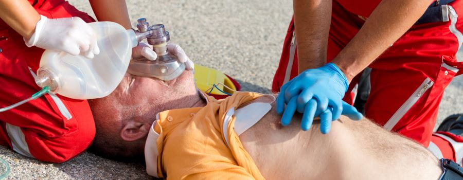 lifeguards performing oxygen resuscitation on a man