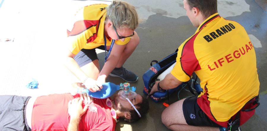 Lifeguards administering oxygen to a patient