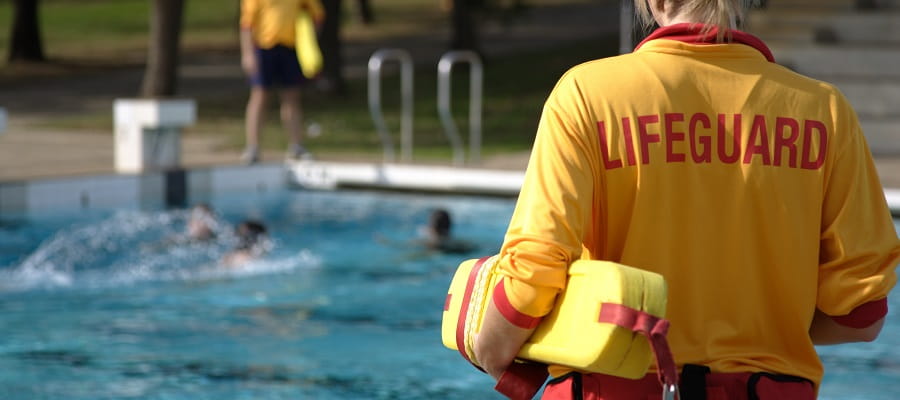 close up of rescue tube under the arm of a pool lifeguard
