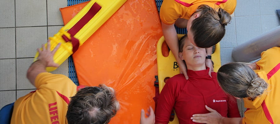 three lifeguards practising spinal injury management