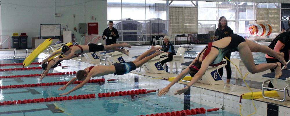 Keen junior lifeguards dive into a pool as part of the recent JLC State Titles