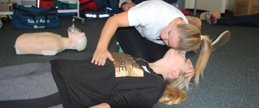 A person practising first response skills in a first aid course