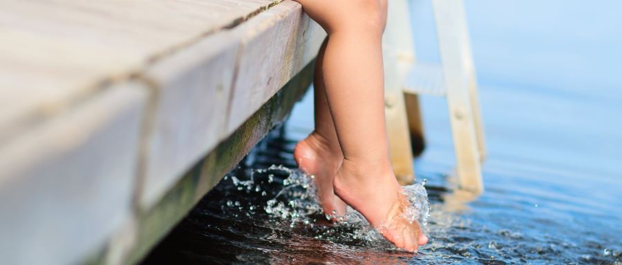 Child dangling her feet in water